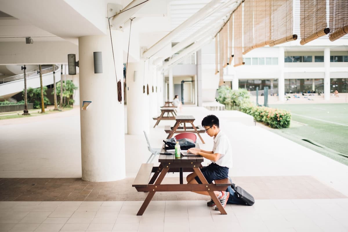 Pelajar mengerjakan tugas dengan laptop di sekolah